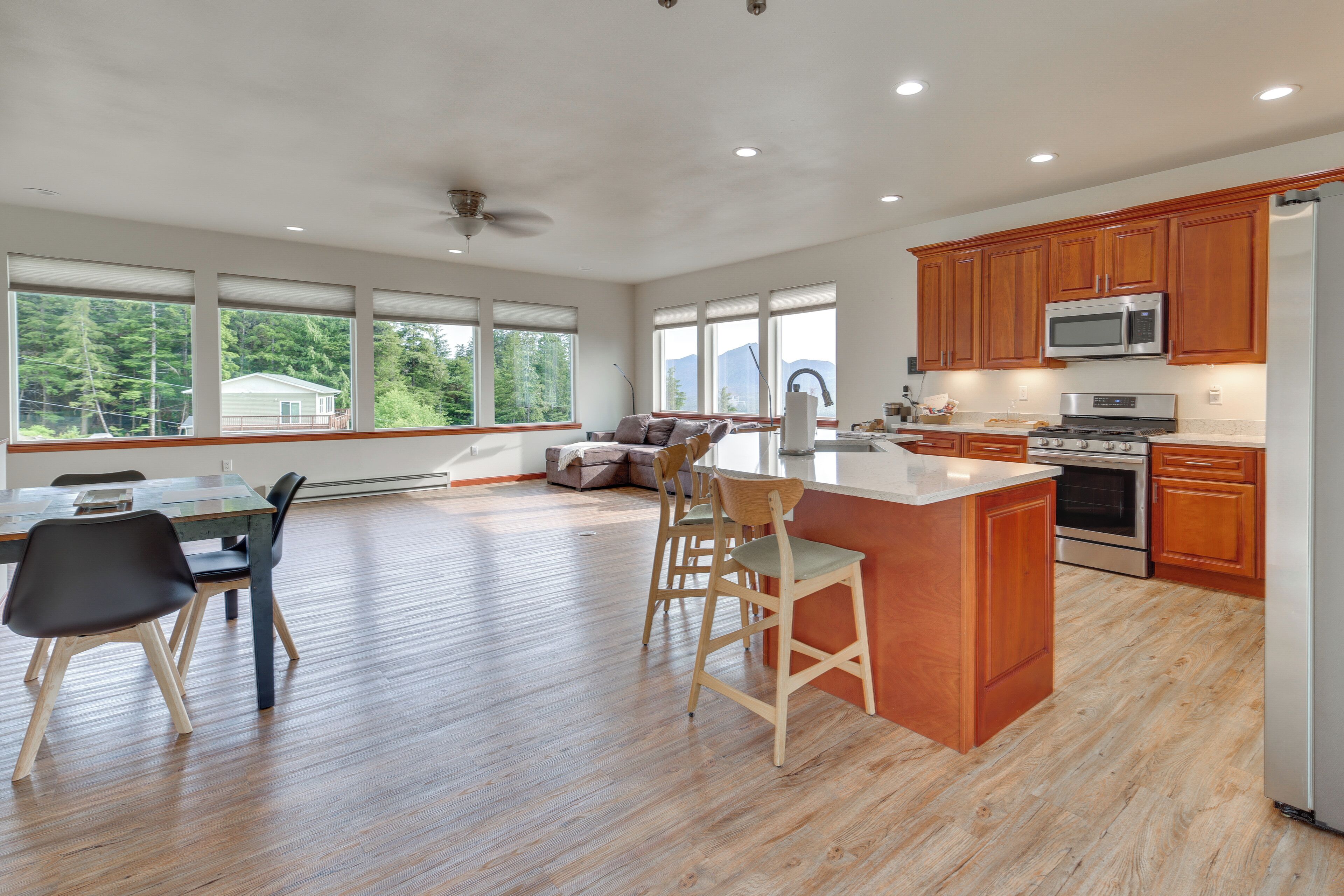 A modern kitchen with wooden cabinets, stainless steel appliances, and a large island with bar stools.