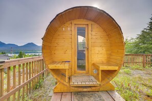 Une cabane en bois avec un toit incurvé, une porte et deux bancs.