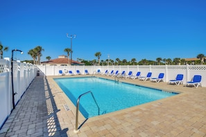 A swimming pool with blue chairs and a white fence. - Walk to Beach! Set of 2 St Augustine Condos (Saint Augustine Beach)