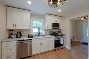 A modern kitchen with white cabinets, stainless steel appliances, and a granite countertop. - Walk to Beach! McCullom Lake Family Getaway (McHenry)