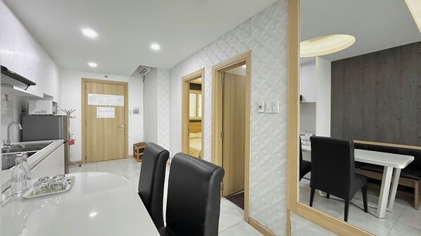 A modern kitchen with a dining area, a microwave, and a refrigerator.