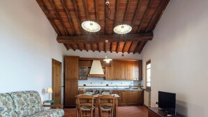 A cozy living room with a sofa and a dining area with a table and chairs. - Vacation Home in Lamporecchio with 1 bedrooms sleeps 4 (Lamporecchio)