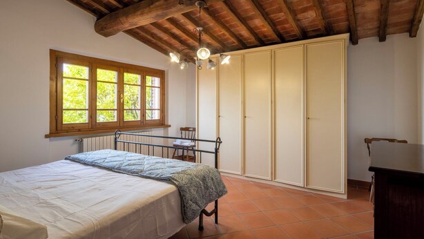 A bedroom with a bed, a window, a wardrobe, and a desk. - Vacation Home in Lamporecchio with 1 bedrooms sleeps 4 (Lamporecchio)