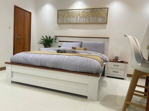 Een moderne slaapkamer met een bed, nachtkastjes, een stoel en een plant.