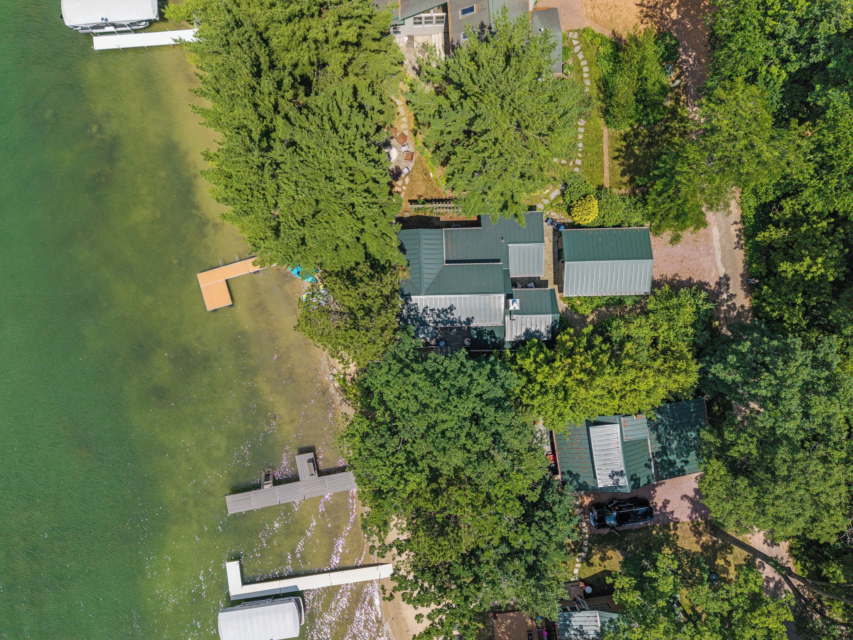 An aerial view of a residential area with houses, a dock, and a lake.