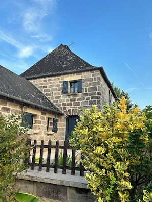 A stone building with a pitched roof, multiple windows, and a visible antenna. - Juliette's House (Ussac)