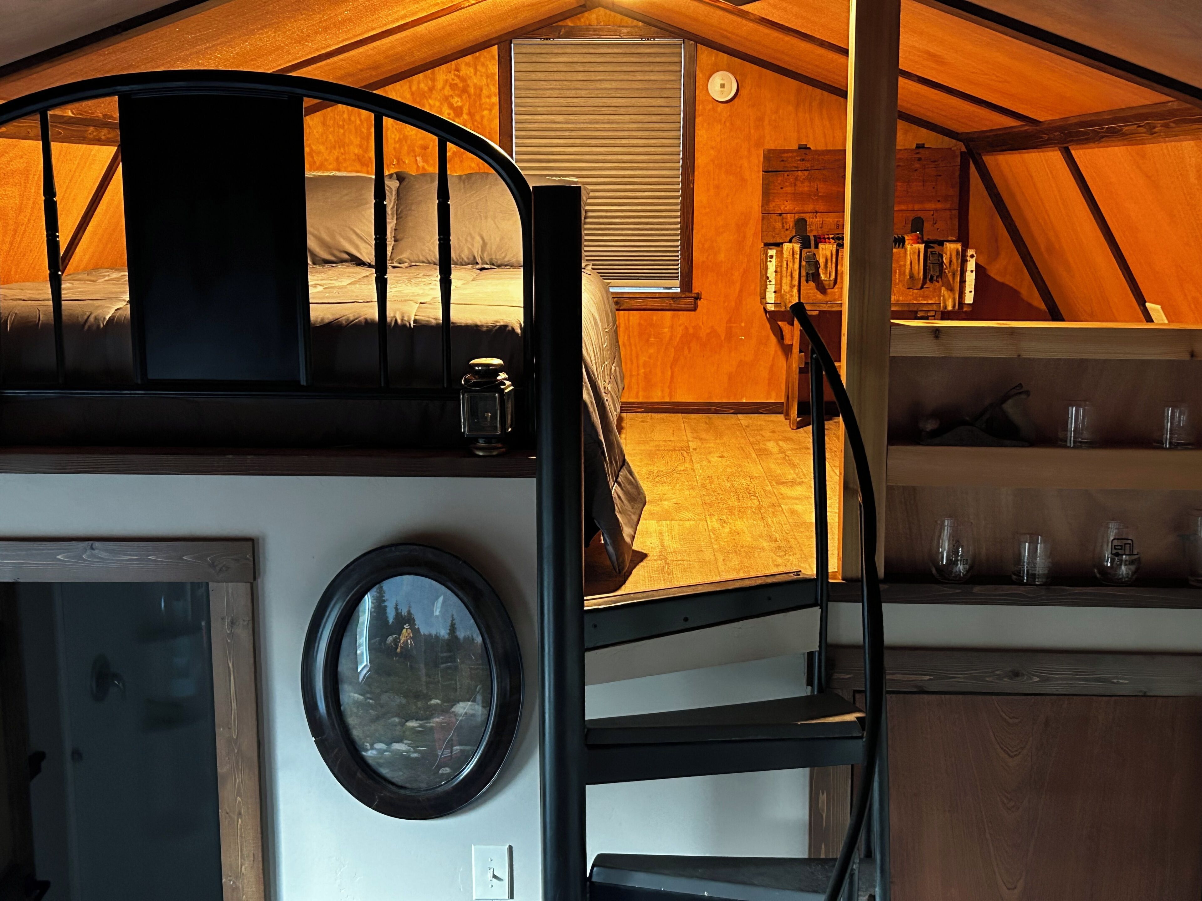 Un intérieur chaleureux avec un lit superposé, une petite table avec des verres et une fenêtre donnant sur une forêt.