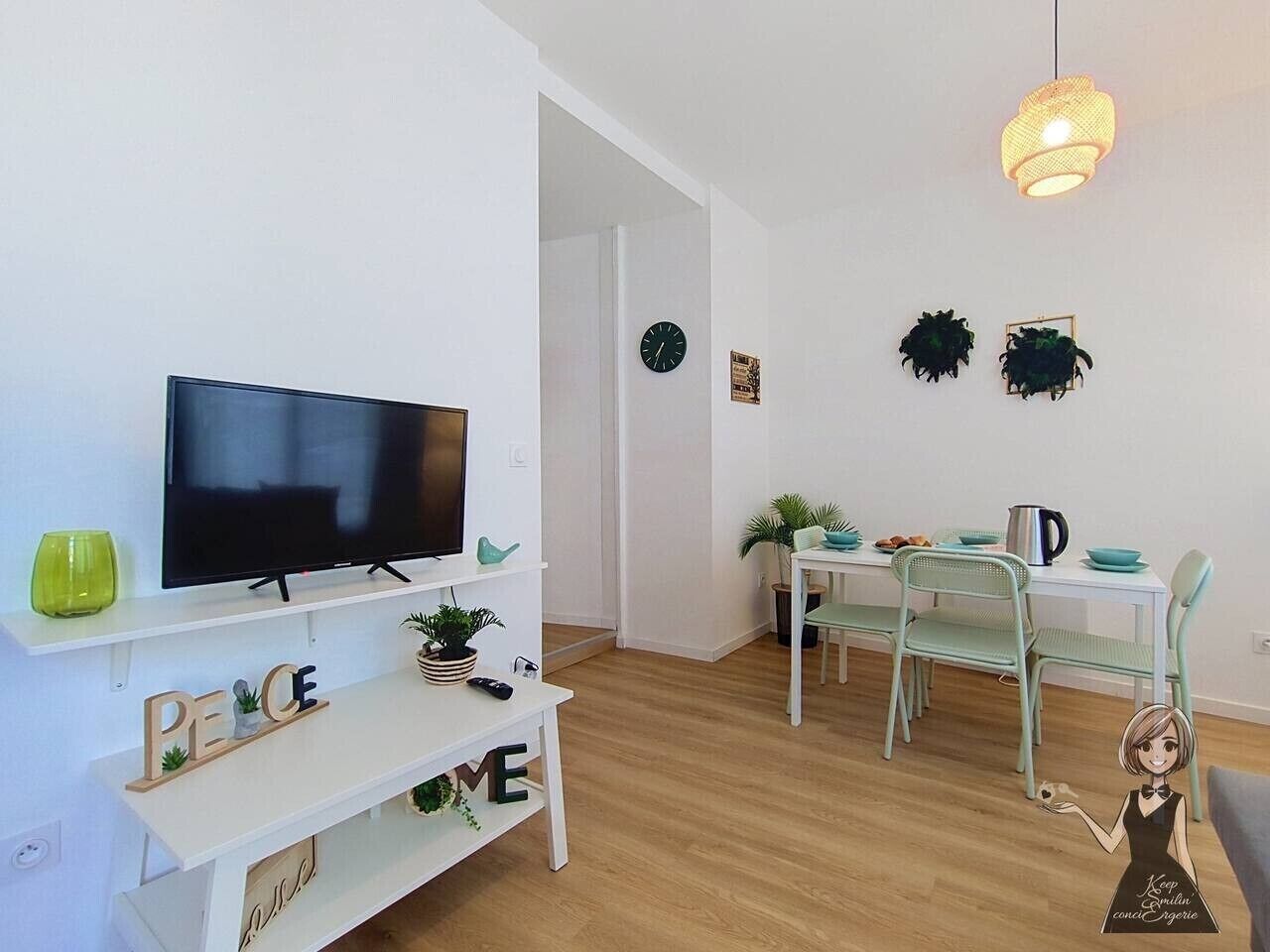 A modern living room with a flat-screen TV, a white console table, a dining area with a white table and green chairs, and a hanging light fixture.