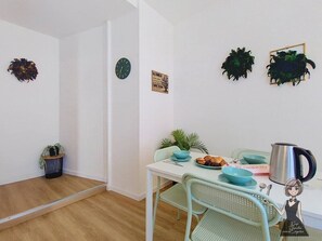 Ein Essbereich mit einem Tisch für zwei Personen, einer Uhr und dekorativer Wandgestaltung.