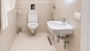 Une salle de bain moderne équipée de toilettes, d’un bidet et d’un lavabo.