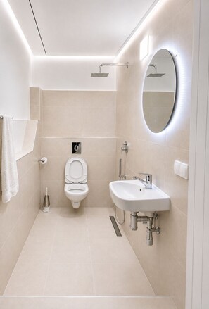 Ein modernes Badezimmer mit Toilette, Bidet und Waschbecken.