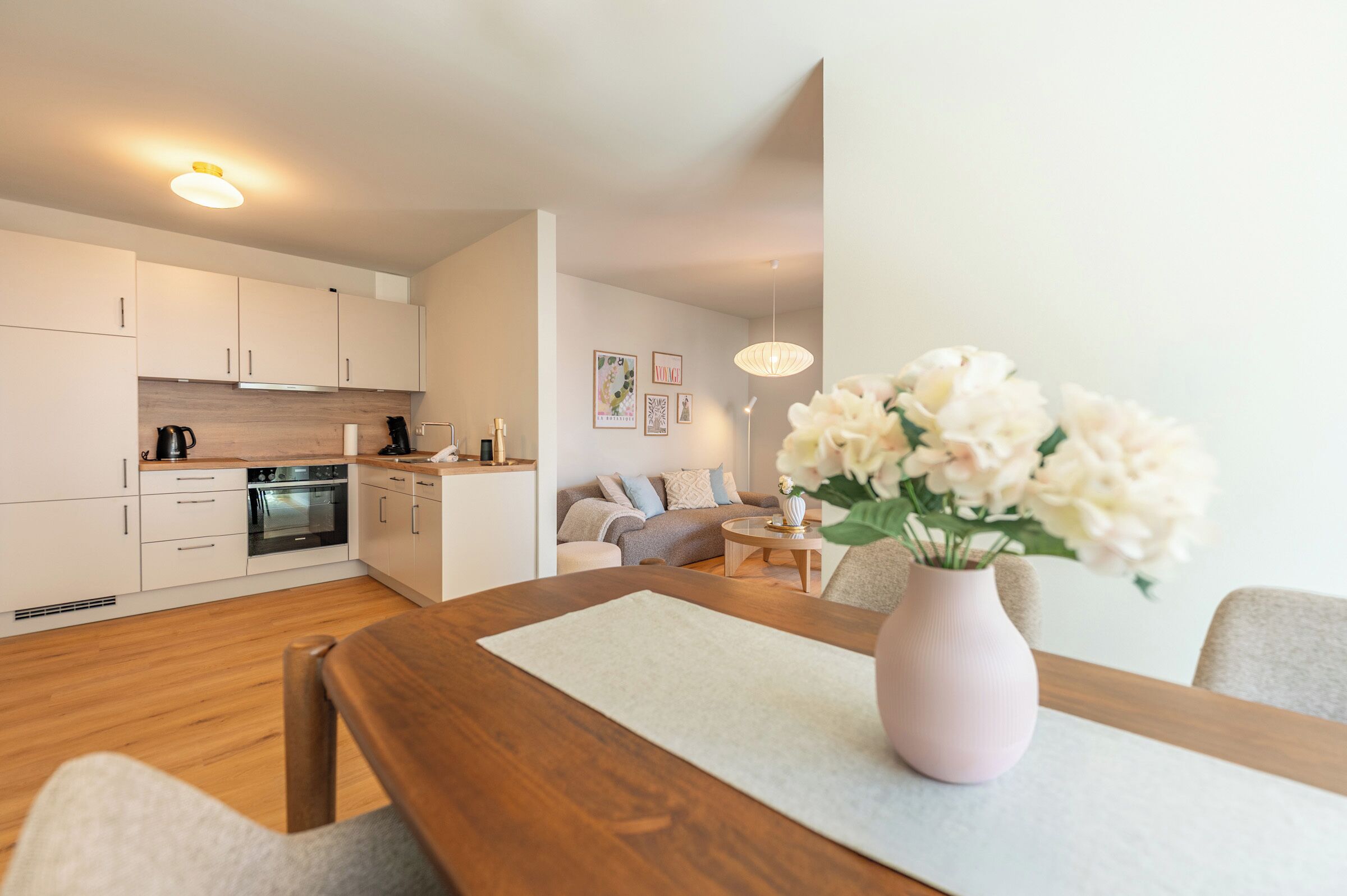 A modern kitchen with white cabinets, a wooden countertop, and a built-in oven.
