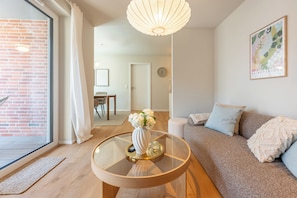 A modern living room with a glass coffee table, a sofa, and a decorative vase. - NordicNeustadt: A Scandinavian-modern apartment in the heart of Husum (Husum)