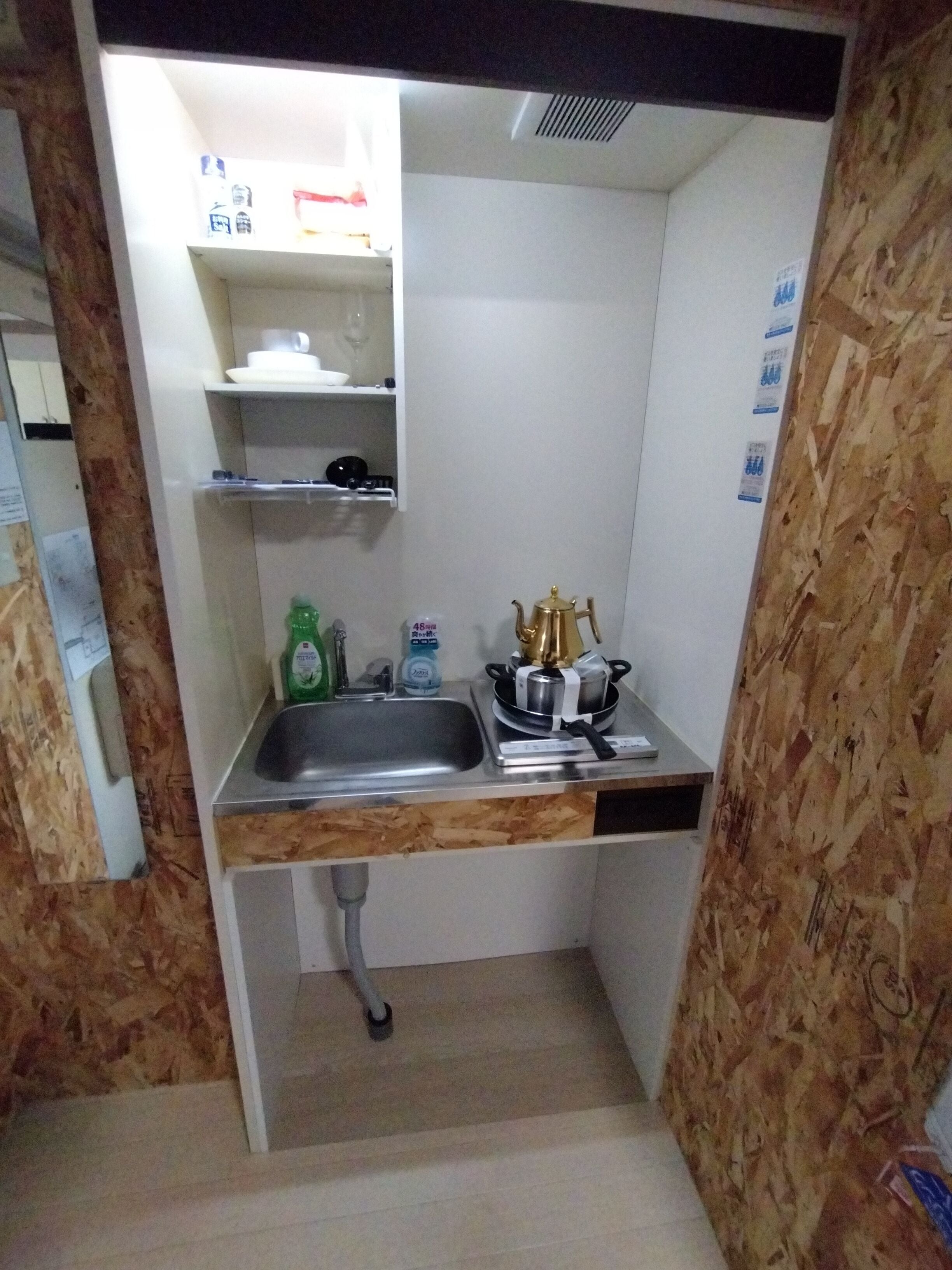 A compact kitchen with a sink, a small countertop, and a stove.