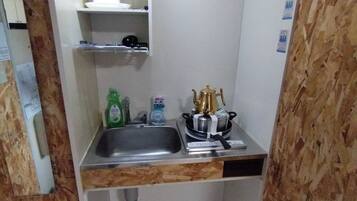 A compact kitchen with a sink, a small countertop, and a stove.