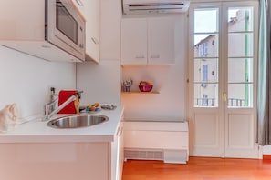 A compact kitchen with a built-in microwave, a sink, and a small countertop. - PIAZZA GRIMALDI AP4519 by Riviera Holiday Homes (Nice)