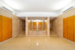 A hotel corridor with wooden lockers on both sides, a tiled floor, and a staircase leading to an upper level. - Experience the Spirit of Historic Lisbon (Lisbon)