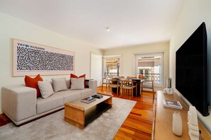 A modern living room with a sofa, coffee table, and a flat-screen TV. - Experience the Spirit of Historic Lisbon (Lisbon)