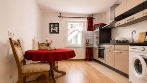 A compact kitchen with a dining area, a washing machine, and a window with a view of the outside. - Cozy apartment in Boppard (Boppard)