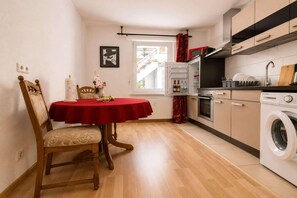 A compact kitchen with a dining area, a washing machine, and a window with a view of the outside. - Cozy apartment in Boppard (Boppard)