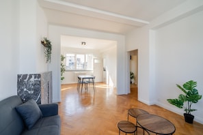 A spacious living area with a sofa, a dining table with chairs, and a potted plant. - Bright & Spacious 3BHK Apartment (Antwerp)