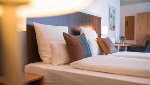 A hotel room with a bed, pillows, a bedside table, and a lamp. - Stuttgart Großbettlingen Hotel by Belvilla Comfort Room (Großbettlingen)