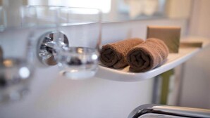 A bathroom with a white sink, two rolled towels, and two clear glasses on a white tray. - Stuttgart Großbettlingen Hotel by Belvilla Comfort Room (Großbettlingen)