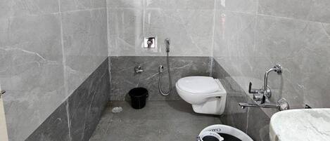 A bathroom with a toilet, bidet, and a sink.