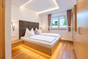 A modern bedroom with a bed, bedside tables, and a wardrobe. - Apartment in Mittersill with terrace (Mittersill)