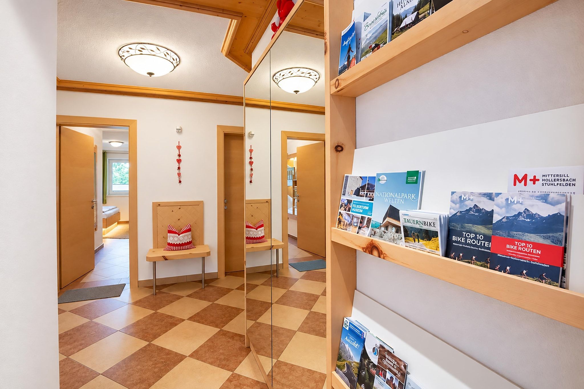 A hotel lobby with check-in counters, a reception desk, and informational brochures on the wall.