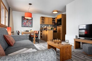 A modern living room with a grey sofa, a wooden coffee table, and a TV on a wooden stand. - Picturesque Mountain Escape for 6 (Flaine)