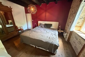 A bedroom with a bed, a mirror, a nightstand, and a hanging light fixture. - Comfortable and authentic holiday home in Orgnac-sur-Vézère on the Vézère (Orgnac-sur-Vézère)