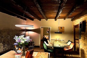 A dining area with a table, chairs, a vase of flowers, and a hanging light fixture. - Comfortable and authentic holiday home in Orgnac-sur-Vézère on the Vézère (Orgnac-sur-Vézère)
