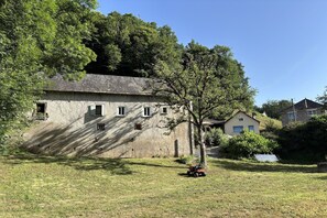 A rustic building with multiple windows and a tree in front. - Comfortable and authentic holiday home in Orgnac-sur-Vézère on the Vézère (Orgnac-sur-Vézère)