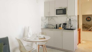 A compact kitchen with a microwave, a sink, and a dining area with a table and chairs. - 1BDR/3P flat - balcony - in the heart of Deauville (Deauville)