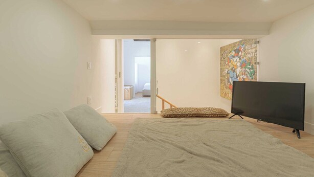 A modern living room with a sofa, a television, and a large rug. - 1BDR/3P flat - balcony - in the heart of Deauville (Deauville)
