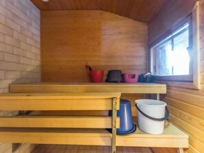 A wooden interior with a bench, a window, and a table with buckets.