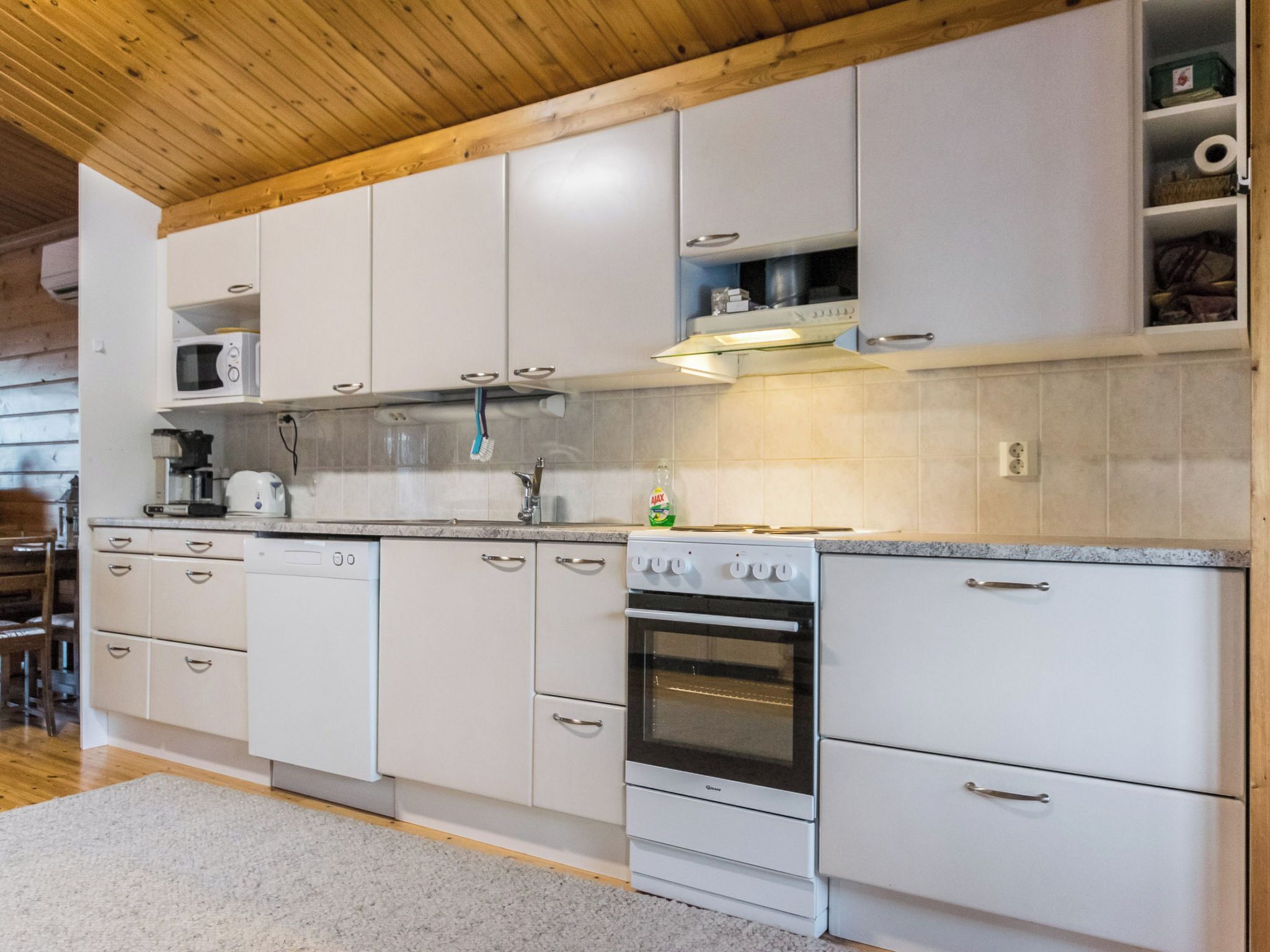 A kitchen with white cabinets, a microwave, a stove, and a dishwasher.