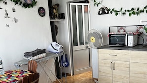 Eine Küche mit Mikrowelle, Abluftventilator und Bügelbrett.