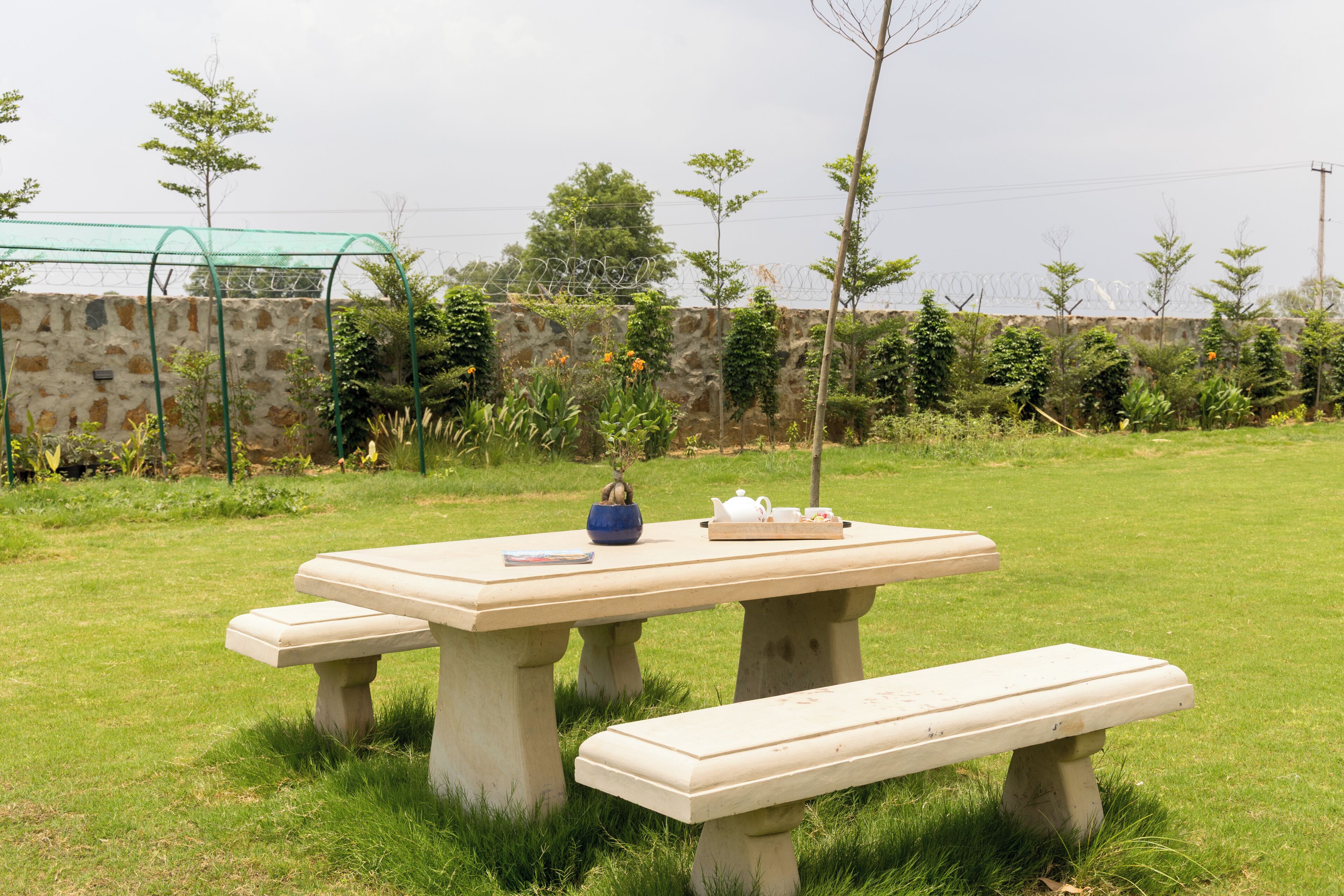 A picnic table with benches in a grassy outdoor area.