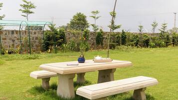 A picnic table with benches in a grassy outdoor area.