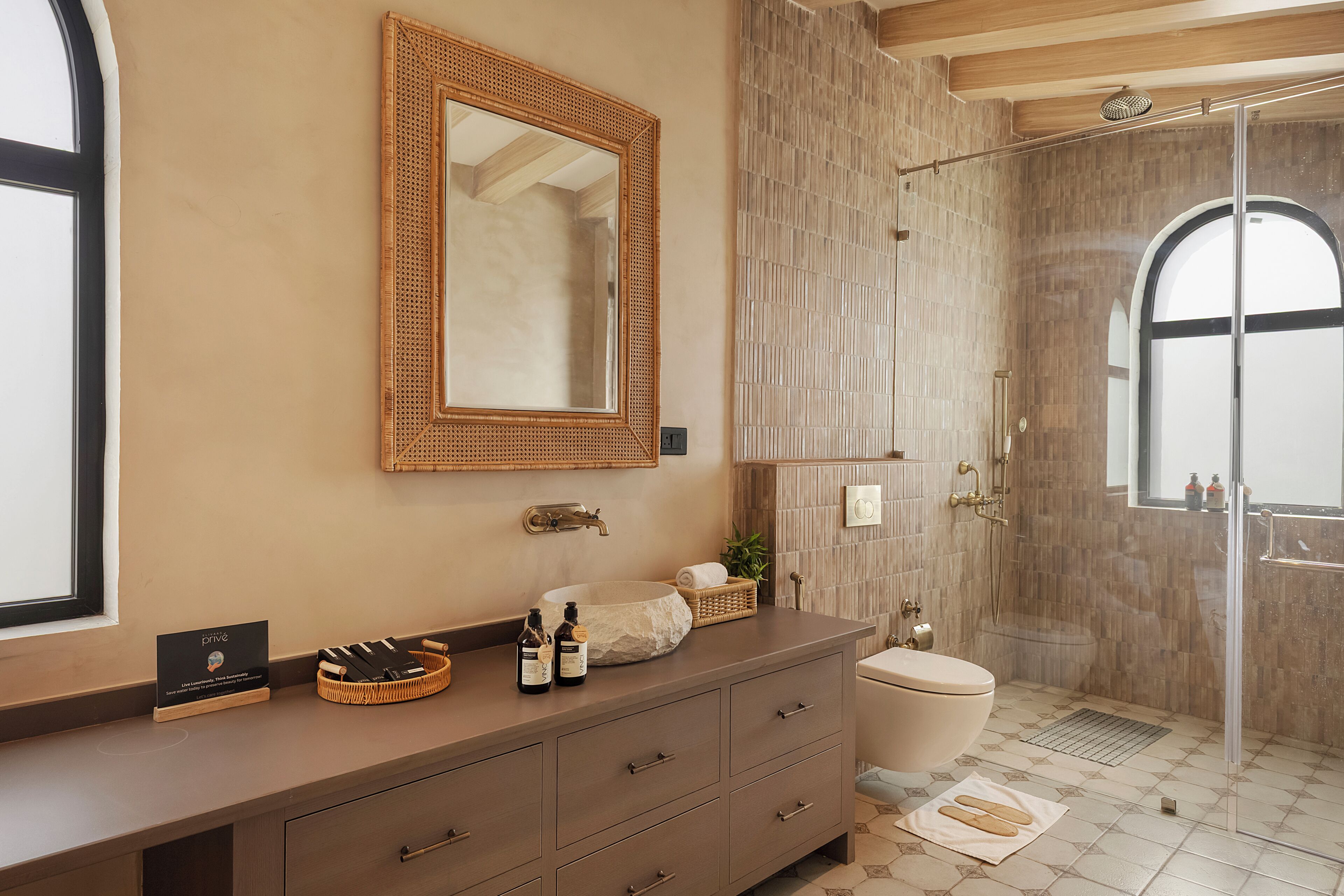A bathroom with a vanity, a mirror, a shower, and a toilet.