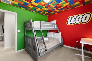 A bunk bed in a room with a LEGO-themed wall and a desk with a computer. - Book Your Christmas Stay/Your Holiday Gift Awaits! (Davenport)