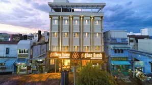 Un hotel con fachada moderna, varios pisos y una entrada destacada con señalización iluminada.