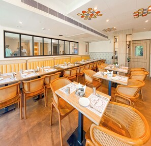 A restaurant with wooden furniture, a long counter, and a mirrored wall.