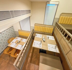 A dining area with wooden tables and benches, equipped with cutlery and napkins. - A1 Diya Palace (Sankarankovil)