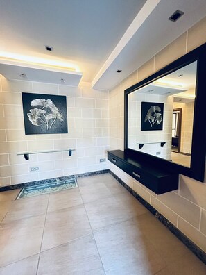 A bathroom with white tiled walls, a black countertop, and a large mirror. - Fabulous 3-bedroom apartment with FULL AC in St. Pauls Bay with Seaview! (San Pawl il-Baħar)