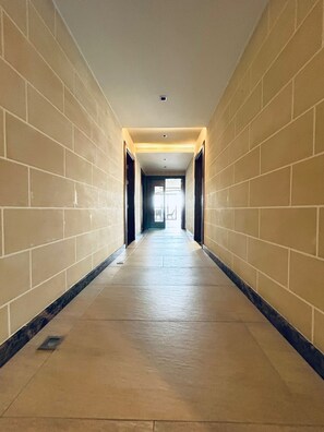 A long, narrow hallway with tiled walls and a tiled floor, leading to a door at the end. - Fabulous 3-bedroom apartment with FULL AC in St. Pauls Bay with Seaview! (San Pawl il-Baħar)