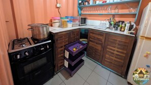 Una cucina compatta con piano cottura a gas, forno e pensili in legno.