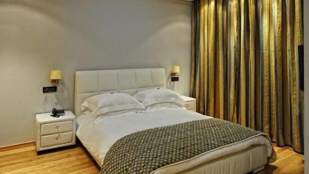 A modern bedroom with a skylight, a bed, bedside tables, and curtains. - Hotel ILIANA (Filippiada)
